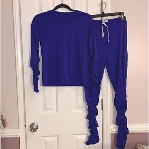 Top and bottom set in Blue gathers on arms and legs of suit. Size Small NWOT